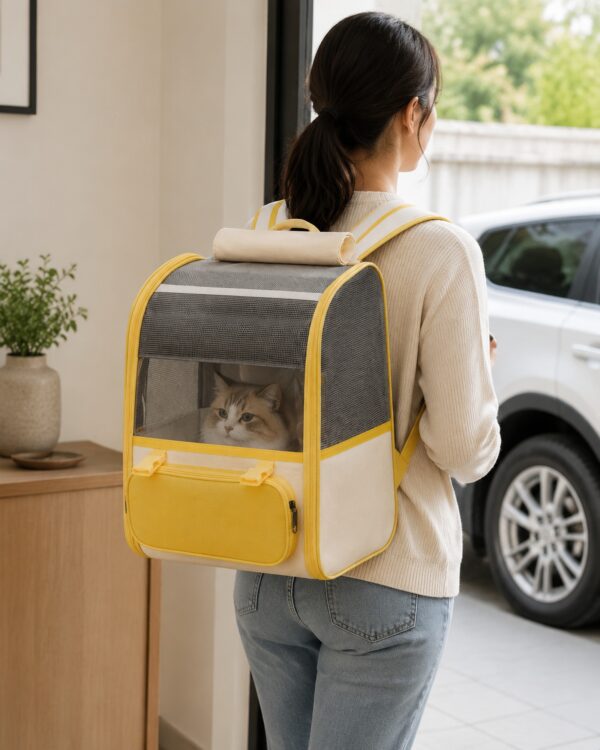 A woman carries the grey pet backpack with a cat inside toward a parked car.