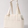 Cream soft pet tote carrier with twin padded handles on a plain background.